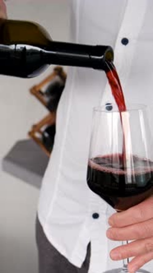 Glass of Red Wine in Hands Selective Focus