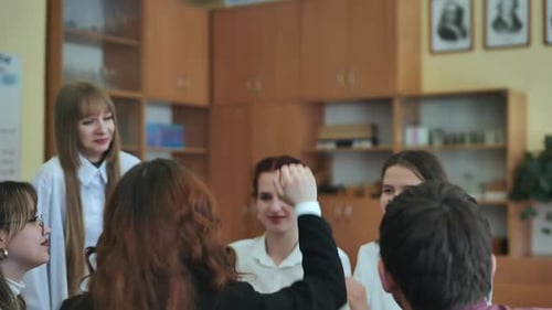 High School Seniors Join Hands in Class As a Sign of Working Together