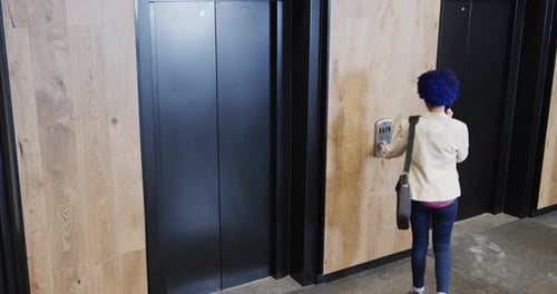 Woman With Phone Waits For Elevator