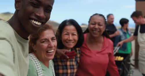 Diverse group smiling, laughing together at outdoor barbecue