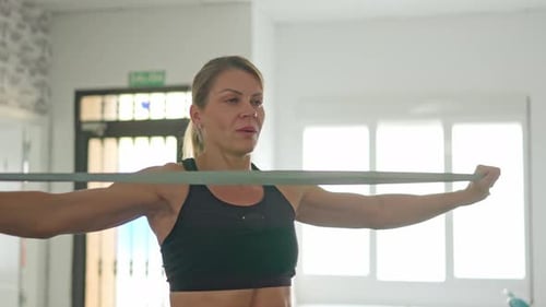 Woman Exercising with Resistance Band at Home