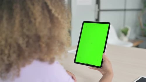 Young African Woman Using Digital Tablet with Chroma Key Screen