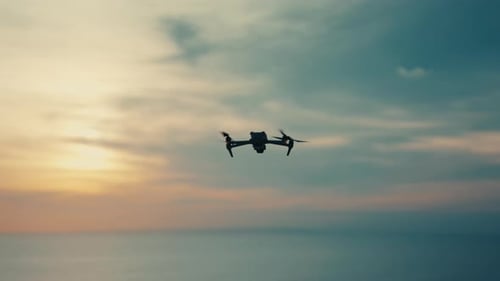 Aerial perspective of a quadcopter hovering in the golden hour sky