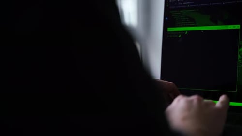 Hands Typing on Laptop with Green Hacking Interface