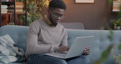 Young Adult Working on Laptop on the Couch