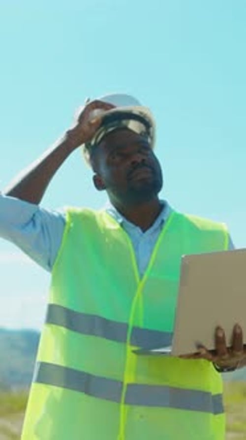 A Construction Worker Meticulously Reviewing and Analyzing Plans Outdoors Under the Sun