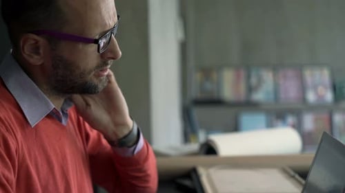 Man Massaging Stiff Neck While Using Laptop