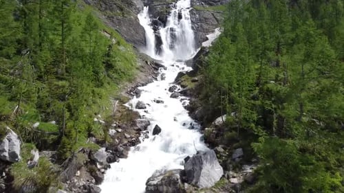 Drone flight to a breathtaking large waterfall in the swiss alps