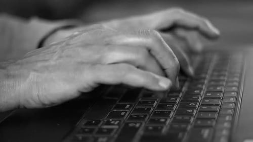 woman in office typing and paying a bill typing on her laptop with people stock video stock footage