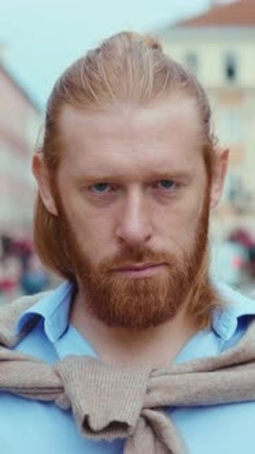 Bearded Man with Long Hair Looks at Camera
