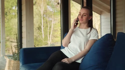 Woman Talking on Cell Phone in Bright Living Room