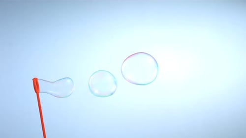 Soap bubbles flowing from an orange bubble wand