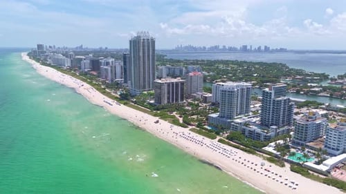 Aerial view of Miami Beach with high-rise buildings and clear water of Atlantic Ocean. Sunny day in