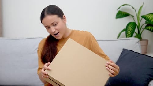Lady on Couch Embracing Package From Online Purchase Appreciating Convenience of Home Delivery