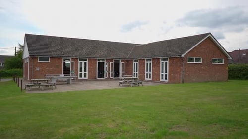 An abandoned house and wooden made table in a park.