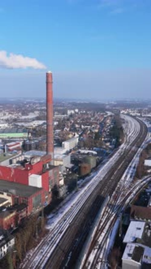 Vertical Static Aerial of Industrial District with Brick Smokestack and Railway Tracks Near the