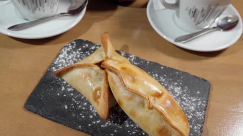 Empanadas fraîches appétissantes sur un plateau en pierre en gros plan avec un service à thé