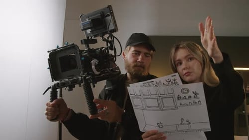 Female Director and Cameraman Discussing Scenes for Shoot in Studio