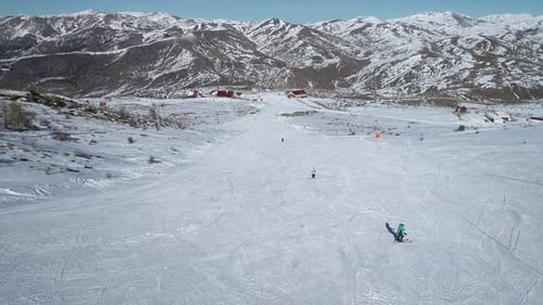 Aerial View Of People Skiing On Snowy Mountain