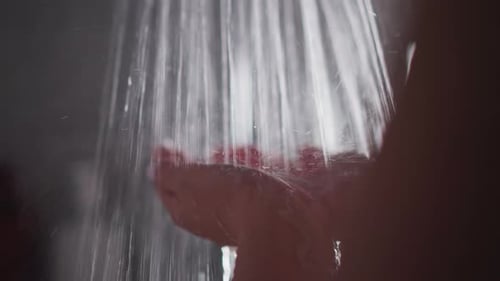 Water Running over Hands in Dark Shower