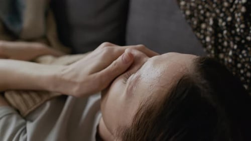 Jeune femme atteinte de grippe virale tousse et essuie la sueur du front