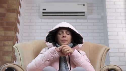 Femme dans une veste chaude dans une chambre froide