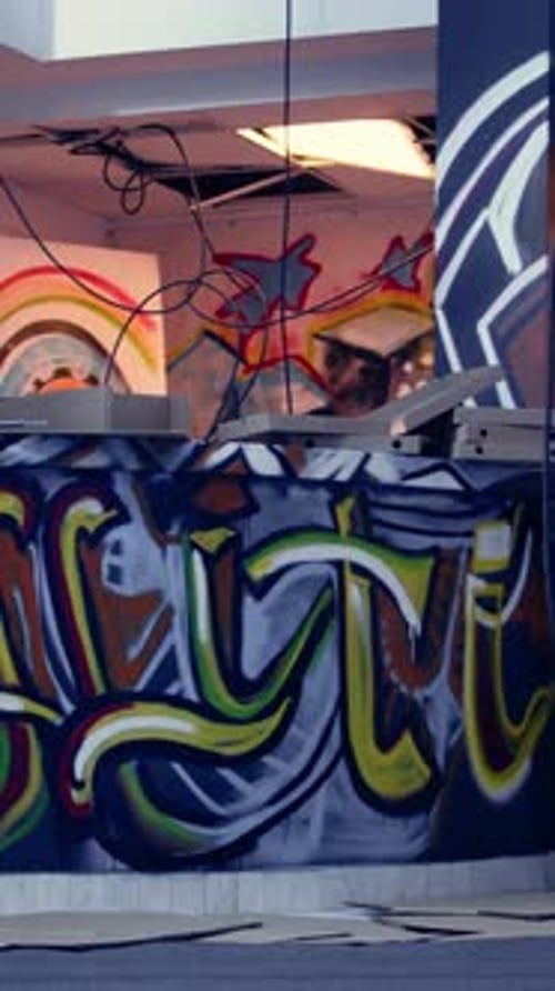 Vídeo vertical, arte de grafite e detritos espalhados em uma localização urbana sem ninguém dentro