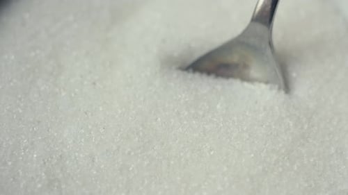 Weißer Zucker in einem Löffel Süße Desserts Eine große Menge Zucker in Lebensmitteln wirkt sich negativ auf die Gesundheit aus