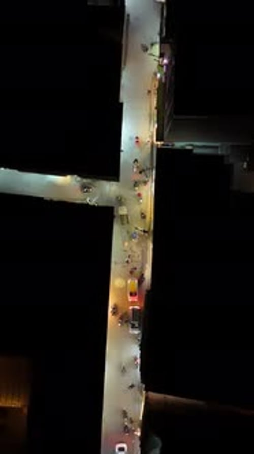 Vertical drone shot above a illuminated street with people and traffic Kathmandu