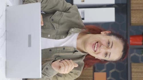 Woman Laughing and Talking on Laptop Video Call