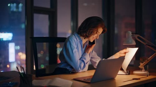 Woman Working on Laptop at Night in Office