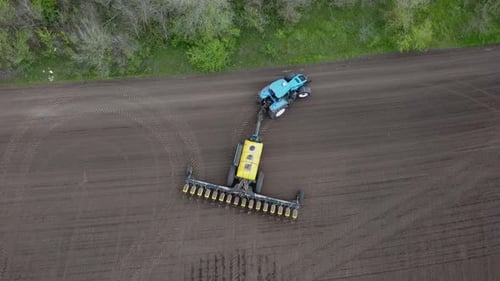 Blue tractor OA working on the field in Ukraine