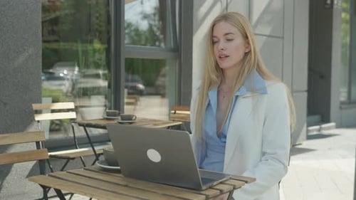 Elegant Freelancer Talking On Video Call While Working From Outdoor Cafe