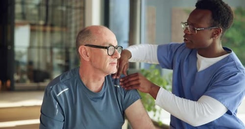 Physiotherapy, massage and shoulder pain with mature man in clinic for rehabilitation