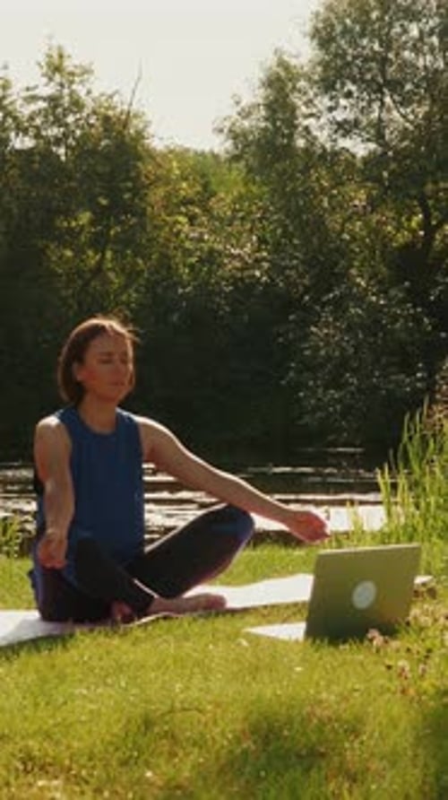 Woman Doing Yoga Outdoors by a Pond