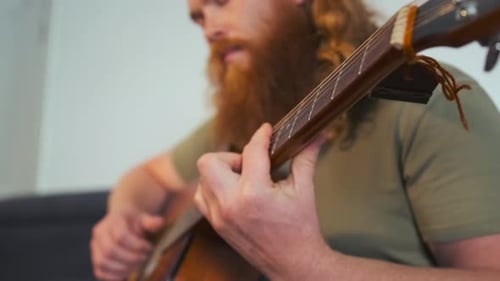 Young Adult Playing Guitar in Living Room