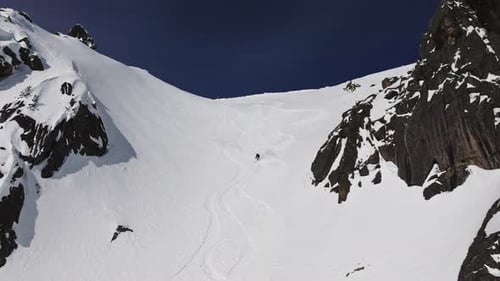 Skilled Freeriders Descending Snowy Mountain Slopes