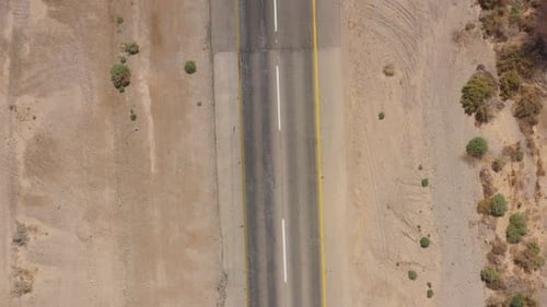Cars driving on a Desert road surrounded by dry land, Aerial view