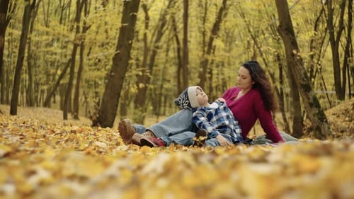 Mother and Child Relaxing in Autumn Leaves