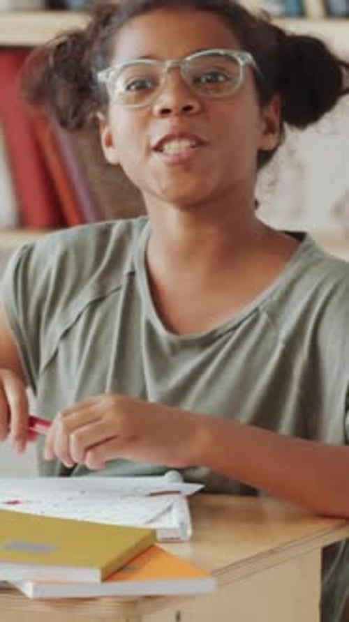 Smiling Girl Answers Question in Classroom Setting