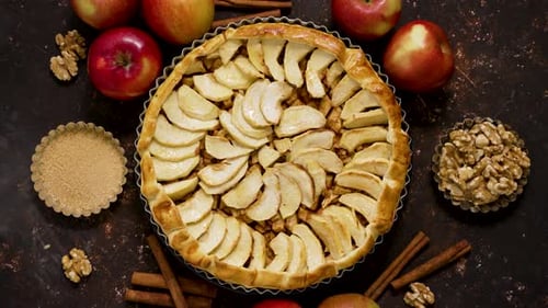 Homemade Delicious Apple Cake with Raisins and Cinnamon Over Rusty Dark Background Top View