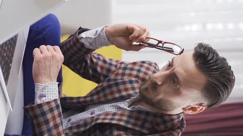 Man Working from Home Cleans Glasses