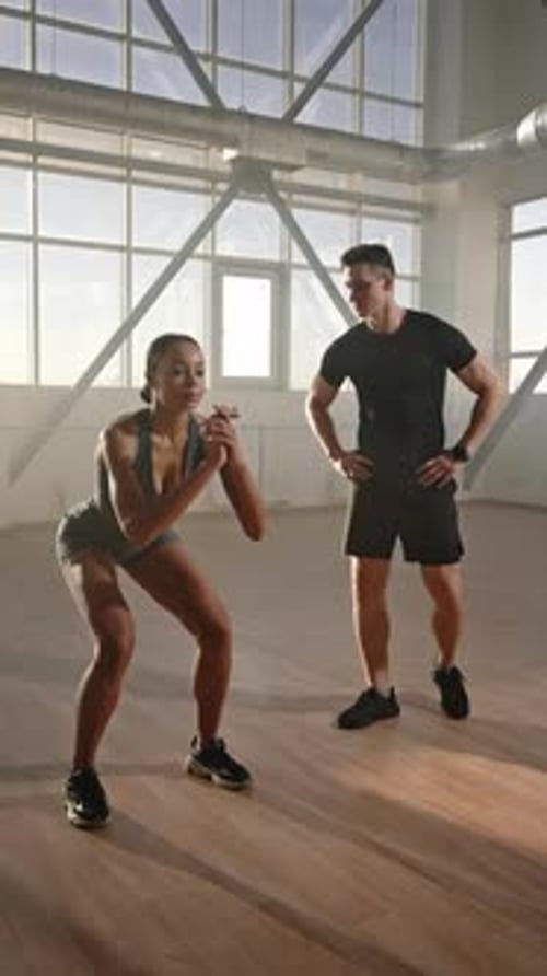 Fit Woman Doing Squats Unde Guidance of Fitness Trainer Gives High Five After Finishing a Workout