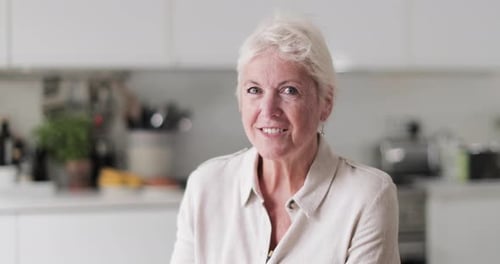 Smiling Mature Woman in Bright Kitchen