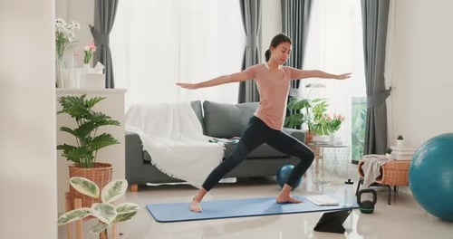 Asia woman in sportswear watching fitness online video on tablet practice yoga for beginner.
