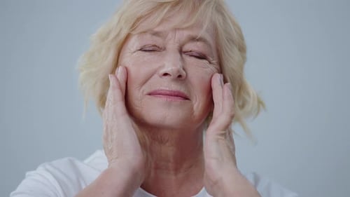Senior woman smiling with hands on face