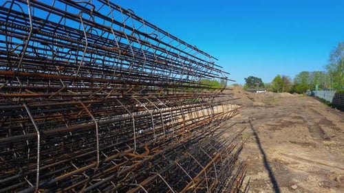 close up shot of metal reinforcement of building foundations laid on the ground in construction site