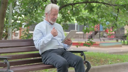 Senior Man Video Calling on Tablet in Park