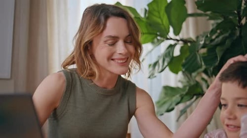 Woman and Child Using Laptop Together at Home