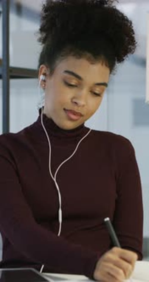 Woman, writing and earphones with notebook in office for planner, story ideas